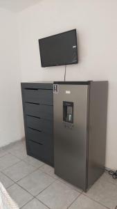 a tv on top of a desk with a refrigerator at Habitaciones el titis in Aguascalientes