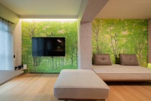 a living room with a couch and a flat screen tv at PaPa's Resort 那須 in Nasushiobara