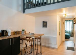 a kitchen with a wooden counter and stools at Duplex Lindor élégant - 2 chambres jusqu'à 4 personnes - Parking gratuit in Angoulême