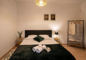 a bedroom with a bed with towels on it at Duplex Lindor élégant - 2 chambres jusqu'à 4 personnes - Parking gratuit in Angoulême