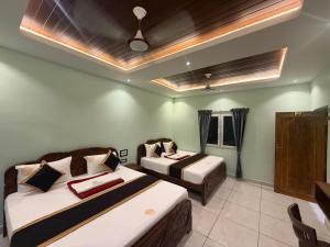 a hotel room with two beds and a table at Nirmala Grand in Rāmeswaram