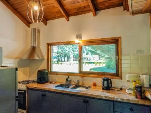 a kitchen with a sink and a window at Casa Cabaña Los Zorzales Santa Clara del Mar-Argentina in Santa Clara del Mar