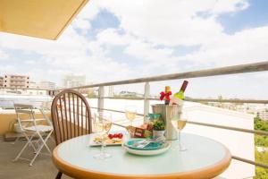 a table with wine glasses and food on a balcony at GUEST HOUSE SORA 2 in Okinawa City