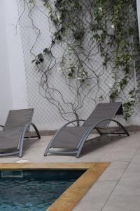 two chairs sitting next to a swimming pool at Hotel Boutique Iyarí in Palmira