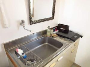 a sink in a kitchen with a mirror above it at GUEST HOUSE SORA 2 in Okinawa City +19 photos