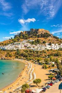 a view of a beach with a town on a hill at Castle & Sea-Panorama Penthouse in Haraki