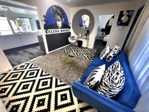 a living room with a blue couch and a mirror at Eleda House - Retro Hidden Gem in Cessnock