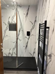 a shower in a bathroom with a marble wall at Cameron apartment Loch Ness in Fort Augustus +35 photos