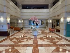 a lobby of a hotel with a vase of flowers at ホテルベルクラシック北見 in Kitami