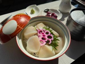 a bowl of dumpling soup on a table at ホテルベルクラシック北見 in Kitami