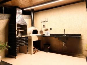 a kitchen with a pizza oven and a sink at Chalé 4 Elementos Teresópolis - vista panorâmica e privacidade in Teresópolis +37 photos