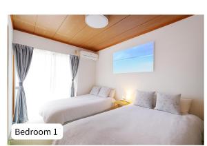 two beds in a room with a window at Quiet Myoden-Disney & Tokyo Sightseeing Base in Ichikawa
