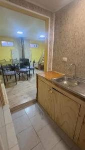 a kitchen with a sink and a living room with a table at Lenayu in Pudeto