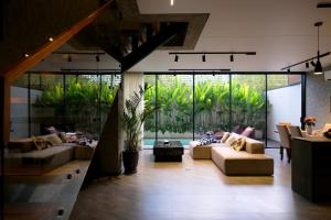 a living room with two couches and a large window at SWOI LOFT UMALAs Designer 2BR Private Pool Villa in Kerobokan