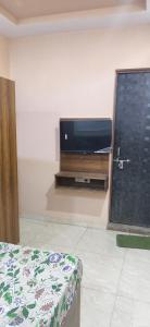 a room with a flat screen tv on a wall at Madhav guest house in Agra