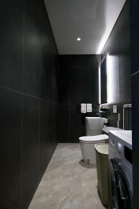 a black bathroom with a toilet and a sink at SWOI LOFT UMALAs Designer 2BR Private Pool Villa in Kerobokan +43 photos