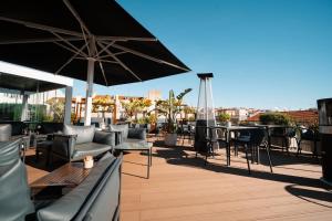 a patio with tables and chairs and an umbrella at The ART INN Lisbon in Lisbon