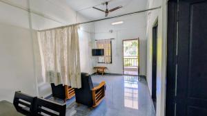 a living room with a chair and a television at Winter Bloom Homestay Munnar in Munnar
