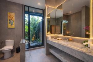 a bathroom with a large sink and a toilet at The Garden Villas in Ubud
