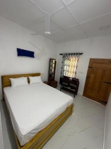 a bedroom with a large bed and a window at U new guest house in Nilaveli