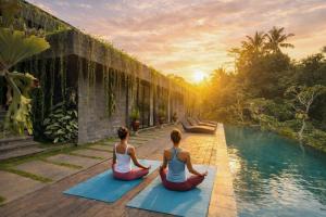 two women sitting in a yoga pose next to a pool at The Garden Villas in Ubud +25 photos