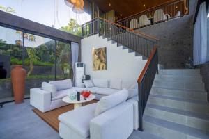 a living room with a couch and a staircase at The Garden Villas in Ubud