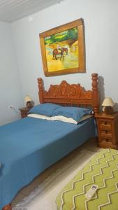 a bedroom with a bed with a painting on the wall at Rancho ABA DO BETIONE in Bodoquena