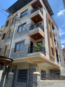 a large white building with a balcony at Paramount Apartment & Rooms in Pokhara
