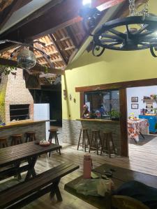 a room with a bar and wooden tables and chairs at Rancho ABA DO BETIONE in Bodoquena