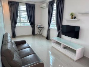 a living room with a couch and a flat screen tv at SPICE Skyview Luxe Tunas 3B2B in Relau