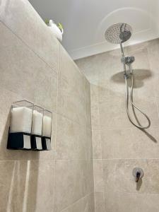 a bathroom with a shower with a shower head at La Porta Rosa in Bunbury
