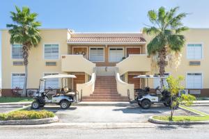 a house with two golf carts parked in front of it at Solimar Villa Family Vacation Spot in Playa de Guayanes