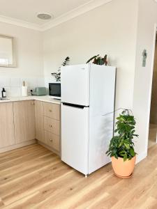 a white refrigerator in a kitchen with a plant at La Porta Rosa in Bunbury
