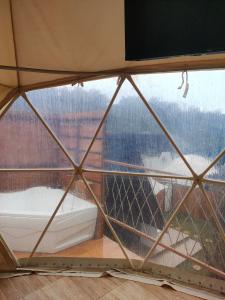 a view from the inside of a yurt window at Glamping Dome Kusumanagara 2 in Bandung