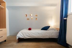 a bedroom with a bed with a blue curtain at Le Bleu et Rubis in Falaise