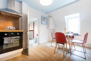 a kitchen and dining room with a table and chairs at Le Bleu et Rubis in Falaise +11 photos