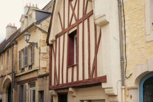 a building with red and white stripes on it at Le Bleu et Rubis in Falaise