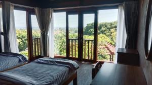 a room with two beds and a large window at Villa WENHOMANN View in Lovina