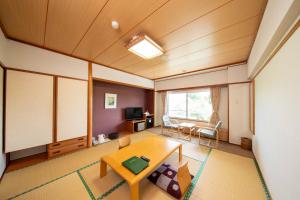 a living room with a table and a dining room at Kyukamura Taishakukyo in Shōbara