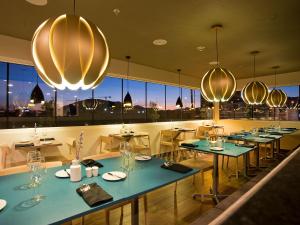 a restaurant with tables and chairs and lights at City Express by Marriott Santiago Aeropuerto in Santiago
