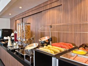 サンティアゴにあるシティ エクスプレス サンティアゴ アエロプエルトのレストランのカウンターの料理を並べたビュッフェ