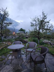 two chairs and a table and a table and chairs at Hotter Potter Stays Manali in Vashisht +21 photos