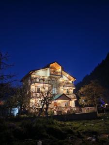 a large building at night with its lights on at Hotter Potter Stays Manali in Vashisht