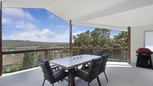 a dining room with a table and chairs on a balcony at For - Resters in Wamberal