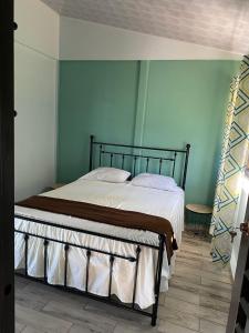 a bed in a room with a green wall at Una Mirada al Atardecer in Pedregoso