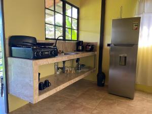 a kitchen with a sink and a refrigerator at Una Mirada al Atardecer in Pedregoso +10 photos