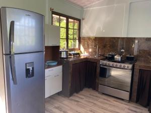 a kitchen with a stainless steel refrigerator and a stove at Una Mirada al Atardecer in Pedregoso