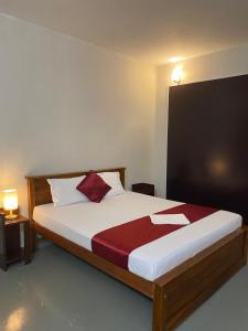 a bedroom with a large bed with a red pillow at MercuryFM 103 Guest House - Colombo 3 in Colombo