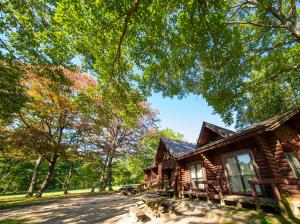 a log cabin in the woods with trees at Kyukamura Taishakukyo in Shōbara