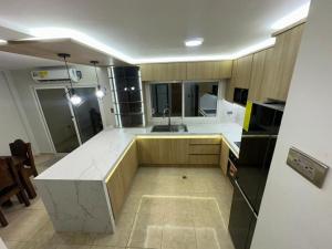 a large kitchen with white countertops and wooden cabinets at Casa Vacacional in Tucacas +4 photos